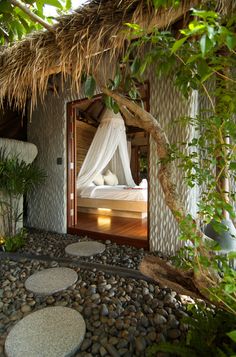 a bed sitting in the middle of a lush green forest