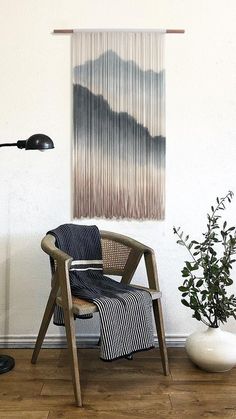 a chair sitting in front of a wall hanging