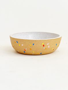 a yellow bowl with sprinkles on it