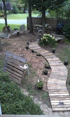 a wooden walkway in the middle of a yard