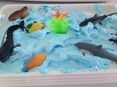 there are many different types of fish in the water on this play dough dish with blue icing and sprinkles