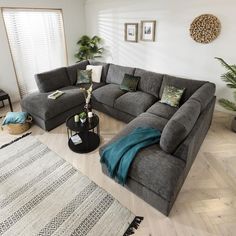 a living room with grey couches and rugs