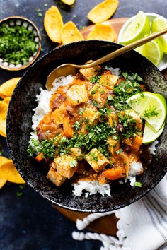 a bowl filled with rice, chicken and cilantro on top of a table