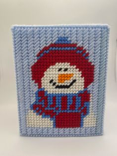 a close up of a small beaded object with a snowman design on it