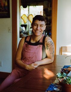 a woman with tattoos sitting at a table