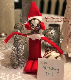 there is a sign that says i'm watching you on the table next to some ornaments