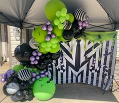 an assortment of balloons are on display under a tent