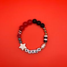 Arrgh, mateys! ️ Set sail for the Gaspirilla Pirate Festival with this red, black and 14k gold beaded bracelet! Shiver me timbers there's freshwater pearls, too! This bracelet features white letter beads with black text.  💜 Every bracelet is unique, so the beads may vary slightly from what is pictured in the product image.  💜 Standard bracelet sizes are 7 inches. You can select a different size using the drop down. 💜 Want multiple bracelets? Select the number from the drop down. 💜 Each brace Red Novelty Beaded Bracelets For Friendship, Black Heishi Beads Jewelry For Friendship, Customized Red Casual Jewelry, Customized Casual Red Jewelry, Casual Customized Red Jewelry, Casual Red Customized Jewelry, Red Heishi Beads Bracelet For Gift, Black Heishi Beads Stretch Bracelet As Gift, Handmade Red Beaded Bracelets In Novelty Style