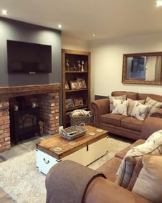 a living room filled with furniture and a flat screen tv mounted on the wall above a fire place