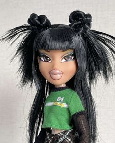 a doll with black hair and green shirt