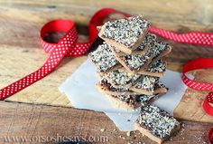 a stack of chocolate bars sitting on top of a cutting board next to a red ribbon