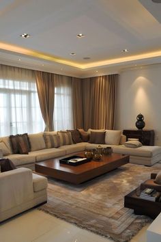 a living room filled with furniture and a large window covered in draping curtains