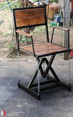 a wooden chair sitting on top of a metal frame with chains hanging from it's legs