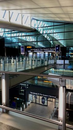 an airport terminal with glass walls and stairs