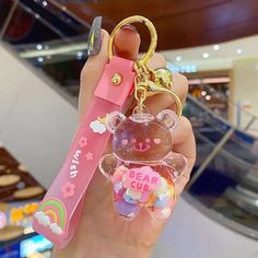 a person holding a keychain in their hand with bear charms on it,