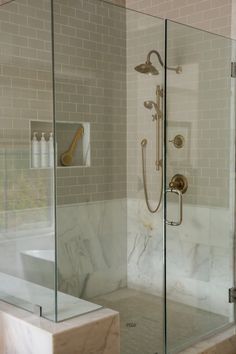 a walk in shower sitting next to a white sink and tub under a faucet