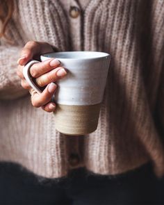 a woman holding a coffee cup in her hands