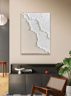 an abstract painting hangs on the wall next to a chair