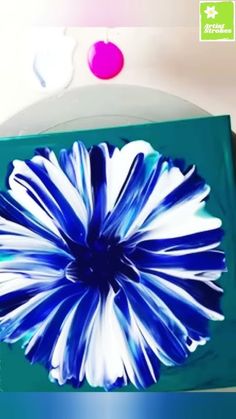 a blue and white flower sitting on top of a green box