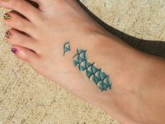 a woman's foot with a fish tattoo on it