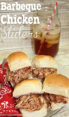 barbecue chicken sliders on a glass plate with a red napkin and beverage in the background