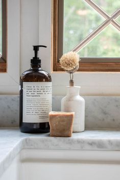 a soap dispenser sitting on top of a counter next to a bottle