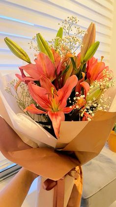 a bouquet of flowers is wrapped in brown paper