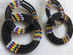 "Black and Multi color Indian style bead dangle earrings, with the small seed beads. They measure 3\" in height and almost 2\" in width. The way the circles are threaded there's a full circle hanging from a circle that's a vertical hoop, so they're perpendicular to each other. Also, please take a look at my storefront at: https://www.etsy.com/shop/FabFinds42?ref=seller-platform-mcnav I have a wide selection of one-of-a-kind items, from clothing and toys to home decor and gift items, and I add ne Black Beaded Drop Earrings With Large Beads, Black Dangle Beaded Earrings, Black Dangle Jewelry With Large Beads, Black Beaded Earrings With Round Beads As Gift, Black Beaded Earrings With Colorful Beads For Gifts, Black Earrings With Colorful Beads, Multicolor Round Beaded Earrings For Festival, Traditional Multicolor Earrings With Colorful Beads, Gift Black Hoop Earrings With Colorful Beads