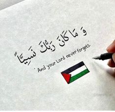 someone is writing in arabic on paper with a pen and ink drawing the word'and your lord never forgets '