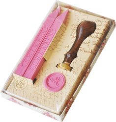 a pink rubber stamp with a wooden handle in a box