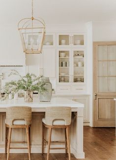 a kitchen with two stools and a center island