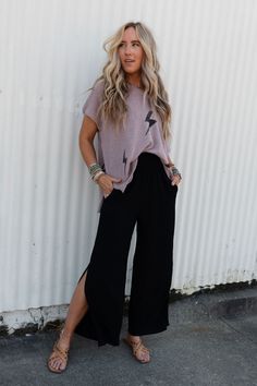 Introducing the Dani Slit Wide Leg Pant - the perfect pants for adding a touch of bohemian style to your wardrobe without sacrificing the comfort! You're going to love wearing these because they feature: Lightweight and flowy woven fabric Gathered, elastic, high-rise waistband with cute mini ruffle detail along the top for a comfortable and flattering fit Flowy wide leg silhouette with cute slits along the sides of the pant legs for added movement and style Side pockets for added convenience Go- Wide Leg Black Pants Outfit, Momma Mia, Comfy Jeans Outfit, 2024 Clothes, Teacher Fits, Black Pants Outfit, Teaching Outfits, Barcelona Fashion