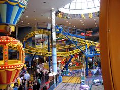 an indoor amusement park with people on the rides