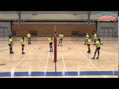 the girls are playing volleyball on the court in yellow shirts and black shorts, while one girl is blocking the ball with her hand