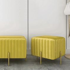 two yellow stools sitting next to each other in front of a white wall and floor