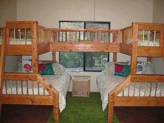 three wooden bunk beds sitting next to each other on top of a green carpeted floor