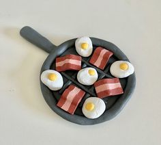 bacon and eggs are arranged in a cast iron skillet on a white counter top