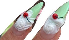 two fingers with fake nails decorated to look like santa's hat and cherries