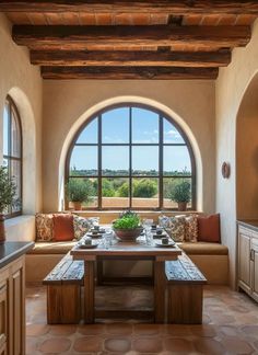 a living room filled with lots of furniture and large arched windows above the couches