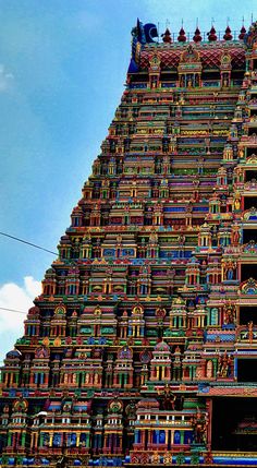 a very tall building with many colorful designs on it's sides and the sky in the background