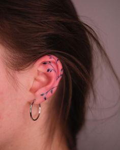 a close up of a person with ear piercings on their ears and behind the ear