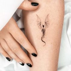 a woman's leg with a small dragon tattoo on the left side of her thigh