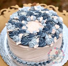 a blue and white frosted cake sitting on top of a table