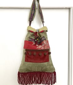 Pretty pull cord green chenille handbag.   There is deep red velvet, also brown bobble trim, 4" long red cotton fringing at the bottom, lots of lovely silky & shiney pieces stitched on for decoration & some colourful beads.  Inside there is one pocket and a small clasp for hanging your keys or a purse etc on.  I did design this purse as a top handle grab bag but for some it may just about fit over the shoulder.   Height:  37 cm (14-1/2 inches) plus the 10 cm (4 inch) fringing  Width:  28 cm (11 Diy Handbags, Deep Red Velvet, Bohemian Purse, Art Bags, Statement Handbag, Boho Purse, Diy Handbag, Boho Purses, Hobo Bags