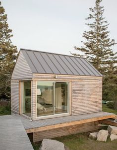 a small wooden cabin sitting on top of a grass covered field