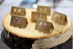 there are many small pieces of jewelry on the wooden slice that is sitting on the table