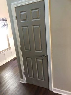 an open door in a room with hard wood flooring and white paint on the walls