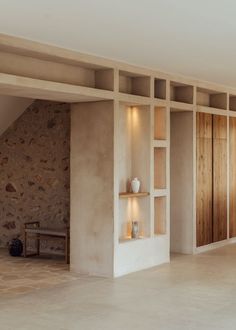 an empty room with stone walls and shelves