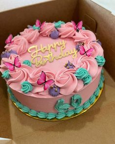 a birthday cake with pink frosting and butterflies on it in a box that says happy birthday