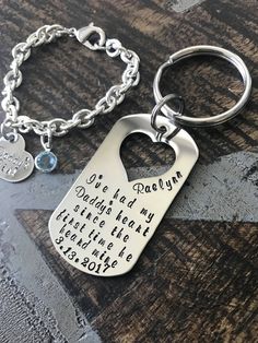 a keychain with two charms attached to it on top of a wooden table